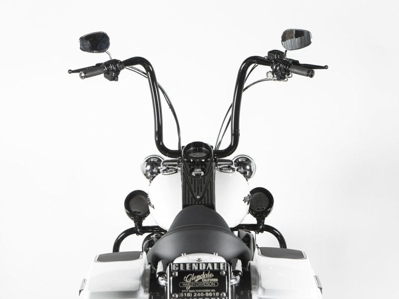 Vintage cruiser motorcycle handlebar with black and white colour scheme, chrome accents, and wide mirrors.