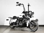 Vintage black and white cruiser motorcycle with leather seat, chrome details, and saddlebags.