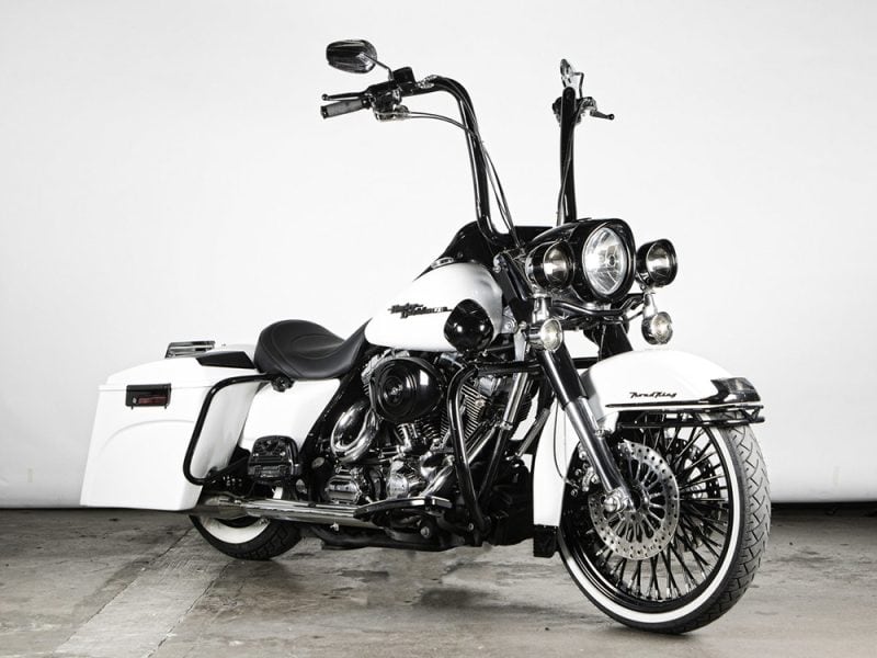Vintage black and white cruiser motorcycle with leather seat, chrome details, and saddlebags.