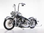 Shiny black and chrome Harley-Davidson motorcycle with custom high handlebars.