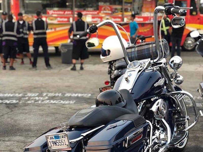 Shiny black Harley-Davidson motorcycle with chrome accents and a windshield at Revelry Cycles Australia.