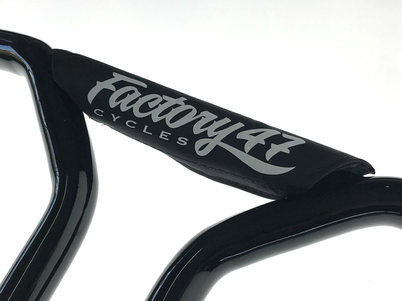 Vintage black bicycle handlebar with "Factory 44 Cycles" branding for Revelry Motorcycles.