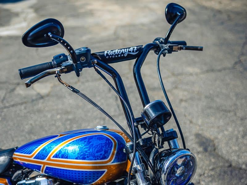 Factory 47 Motorcycles handlebar and front view, showcasing custom blue and orange motorcycle design.