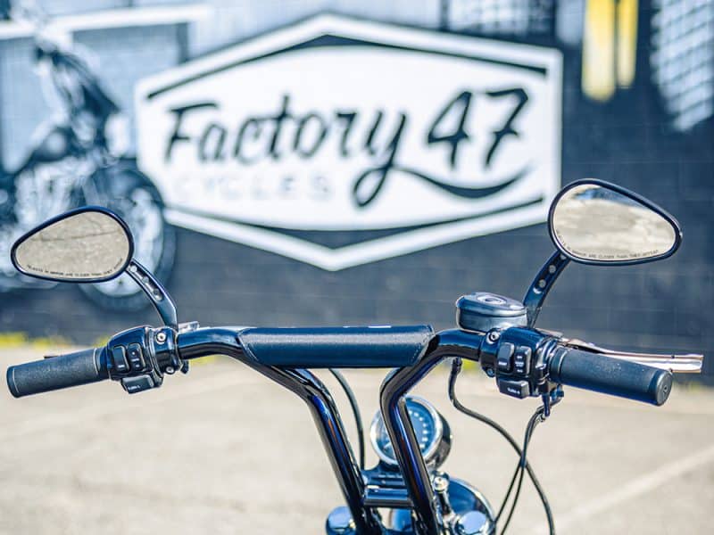 Motorcycle handlebar with mirrors at Revelry Cycles, showcasing custom cruiser bikes.