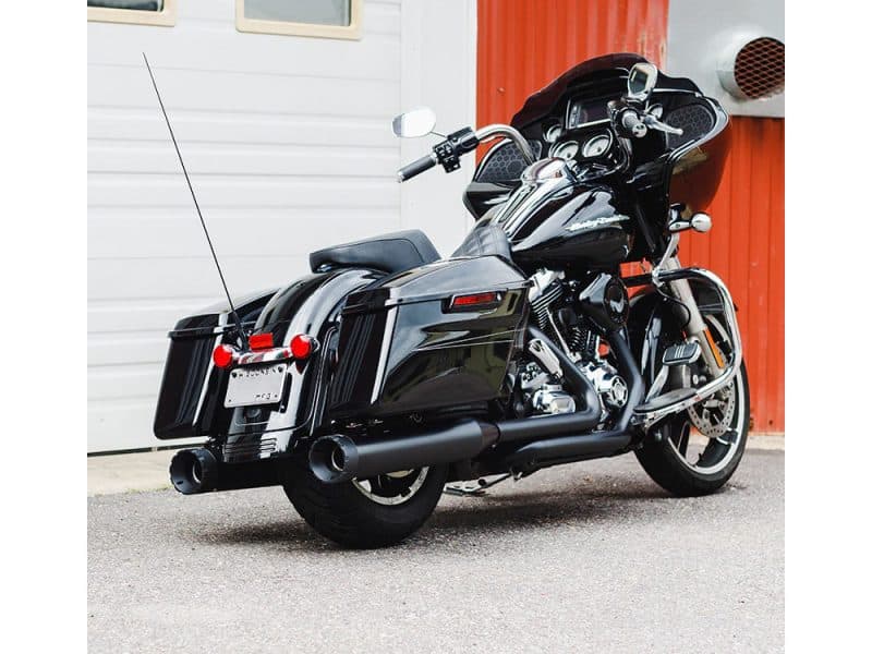 Motorcycle sitting on asphalt with black leather seats and large wind deflectors; Revelry Motorcycles featured.