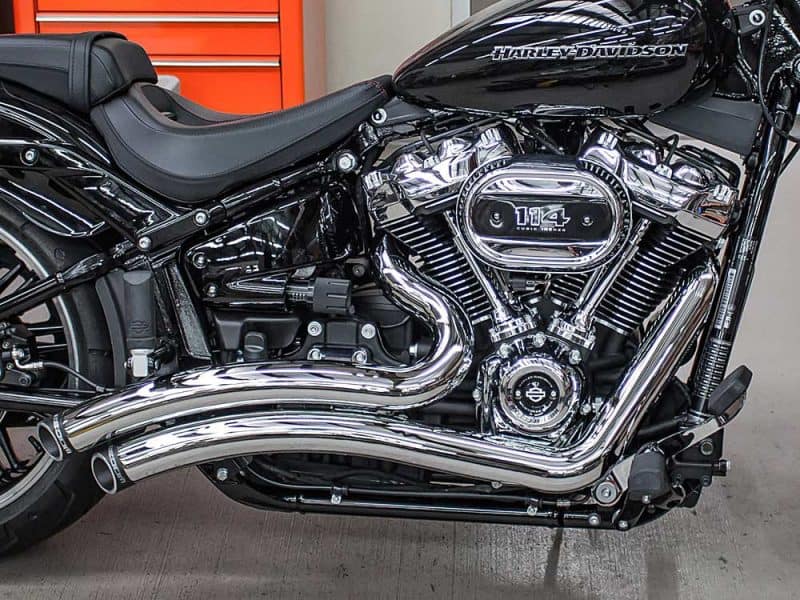 Vivid black Harley-Davidson motorcycle with chrome engine and exhaust, showcased at Revelry Motorcycles.
