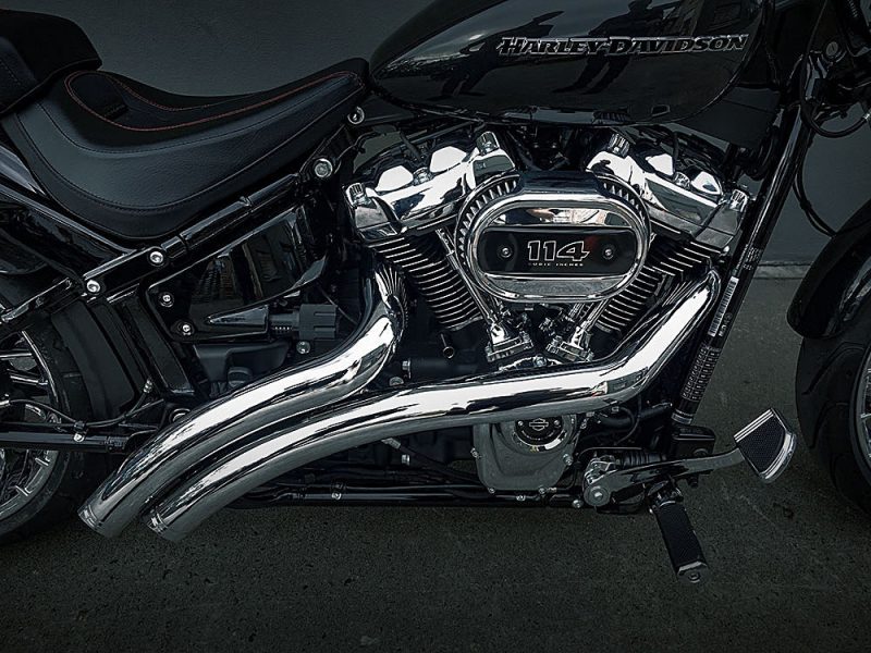 Chrome Harley-Davidson engine and exhaust on a black motorcycle from Revelry Motorcycles, showcasing premium Harley accessories.