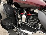 Vivid close-up of Harley Davidson motorcycle engine with chrome and black components.