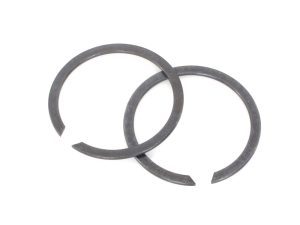 Two metal circlips for motorcycle engine repair or maintenance.