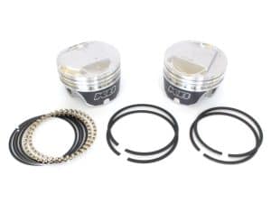 High-performance motorcycle pistons with piston rings and connecting rod bolts for Revelry Motorcycles.
