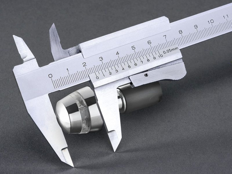 High-precision digital caliper measuring motorcycle part, showcasing accurate measurement tools for motorcycle manufacturing.