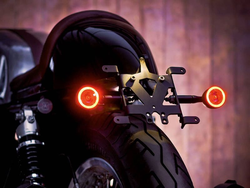 Sleek black motorcycle with illuminated rear lights, custom mount for number plate or license plate.