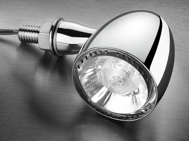 Chrome motorcycle LED headlight with wiring harness for Revelry Motorcycles.