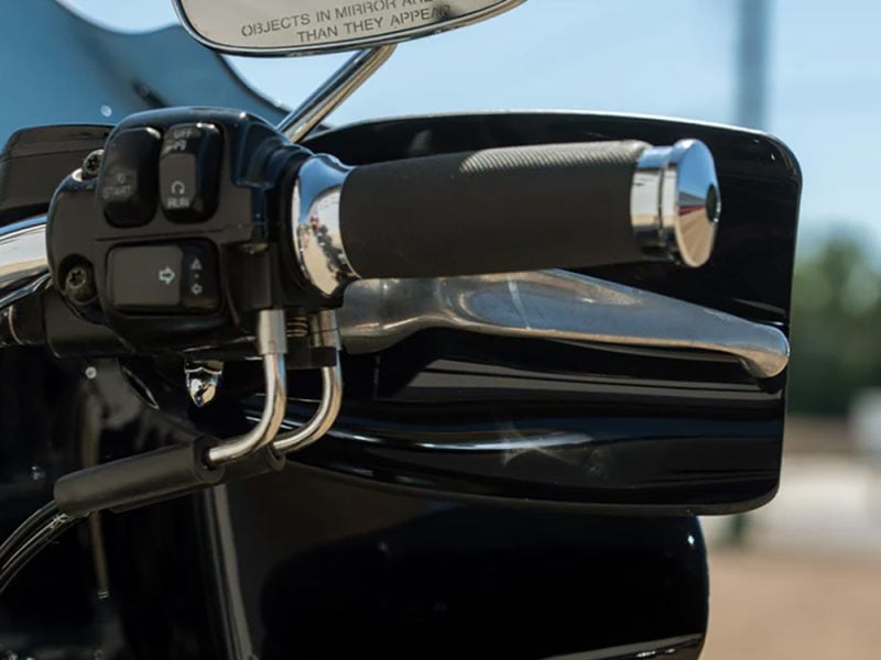 Sleek motorcycle handlebar with black grips and chrome accents, perfect for Harley or cruiser bikes.