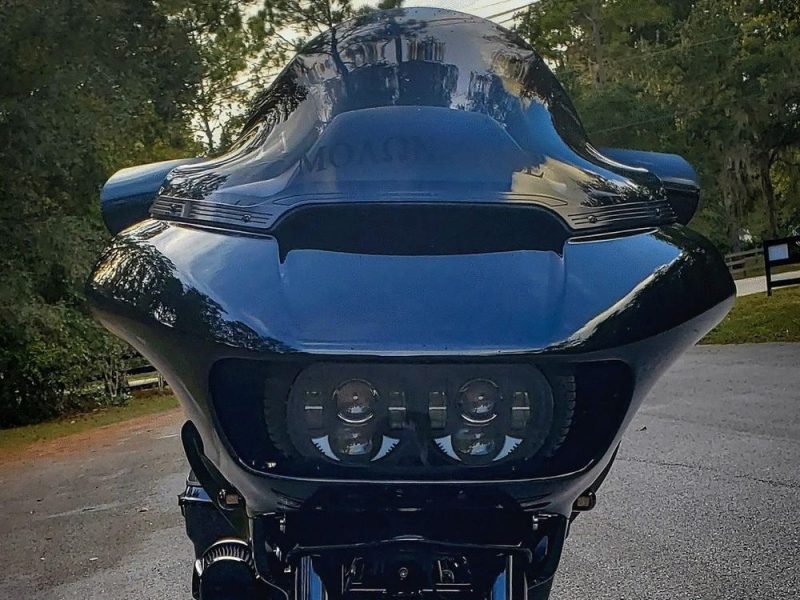 Shiny black Revelry Motorcycles touring motorcycle with aerodynamic fairing and advanced LED headlights.