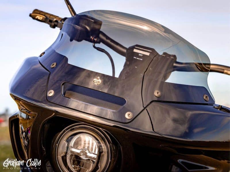 Sleek black motorcycle with tinted windshield, showcasing high-performance design and advanced aerodynamics.