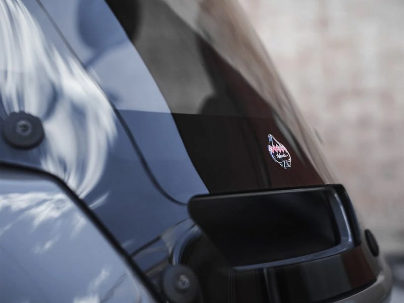 Vintage motorcycle badge on black glossy bike, close-up shot.