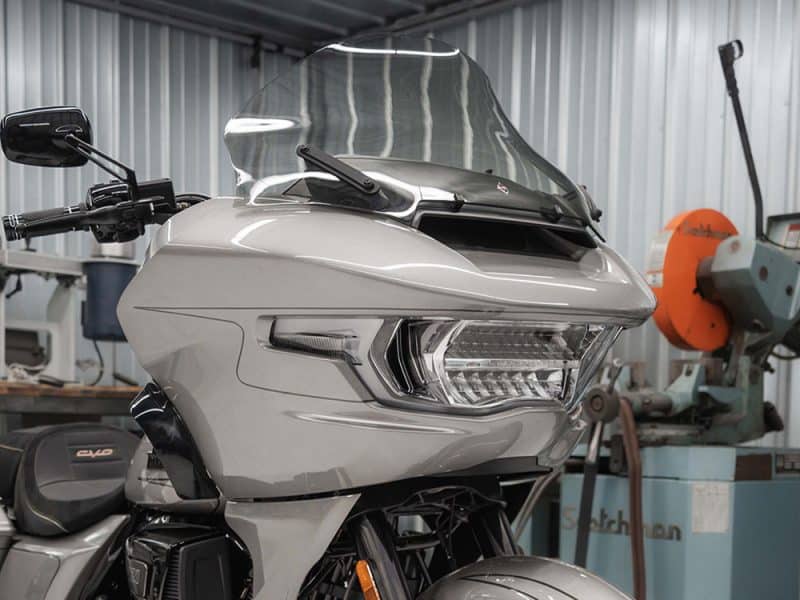 Futuristic motorcycle front view with aerodynamic fairing and advanced lighting, showcasing quality craftsmanship.