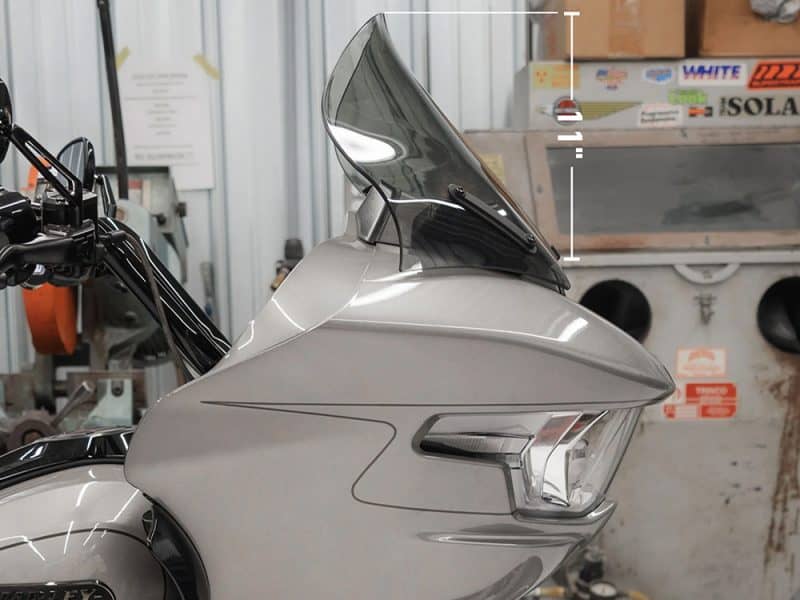 Shiny motorcycle front with large windscreen and modern design.