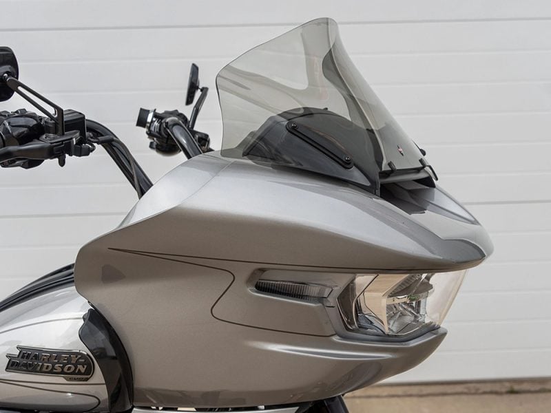 Sleek silver touring motorcycle with advanced windscreen and modern lighting for optimal touring comfort.