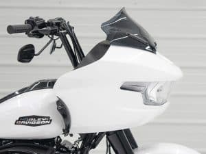 Vintage Harley-Davidson motorcycle with custom white fairing and black accents for motorcycle enthusiasts.