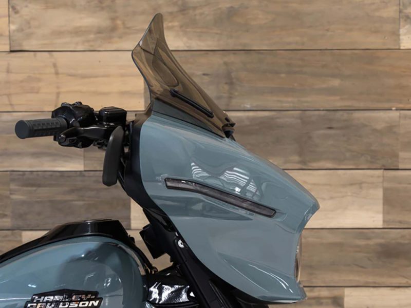 Sleek blue motorcycle with tinted windshield in Revelry Motorcycles showroom.