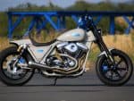 Custom grey motorcycle with blue accents and chrome engine, ideal for motorcycle enthusiasts.