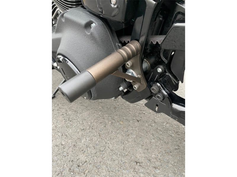Motorcycle footpeg and gear shift lever on black Revelry Motorcycles bike.