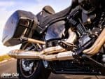 High-performance black and gold motorcycle engine with custom exhaust pipes for motorcycling enthusiasts.