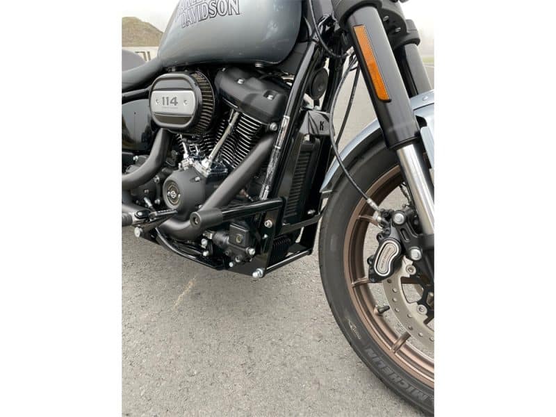 Harley Davidson motorcycle engine and front wheel, black and bronze detailing, modern bike design.