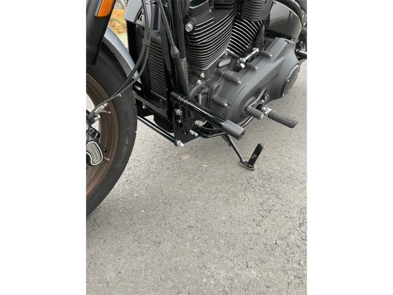 Black motorcycle engine and footpeg at Revelry Motorcycles, Australian custom motorcycle shop.