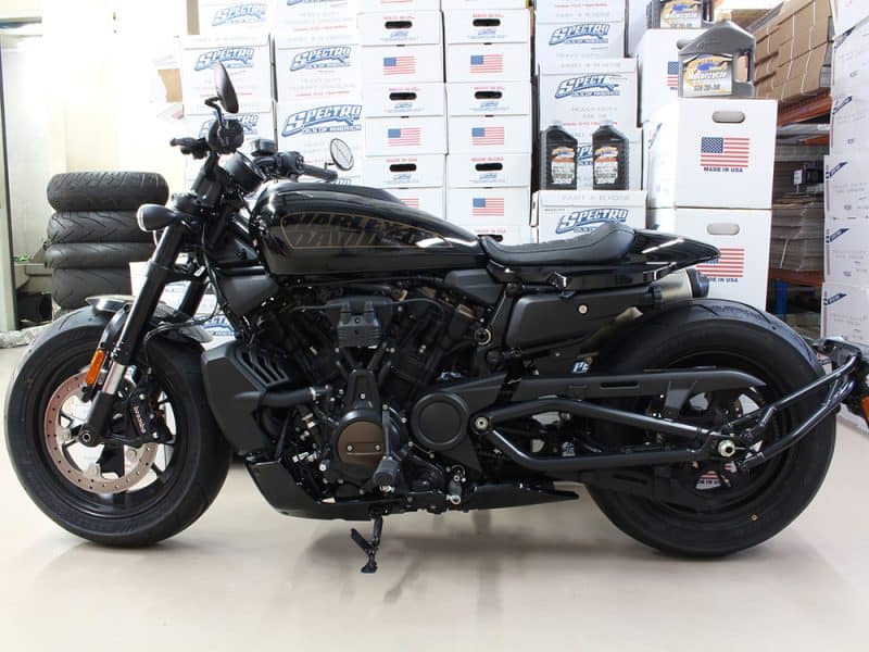Harley Davidson black motorcycle in a store with truck tires and boxes in the background.