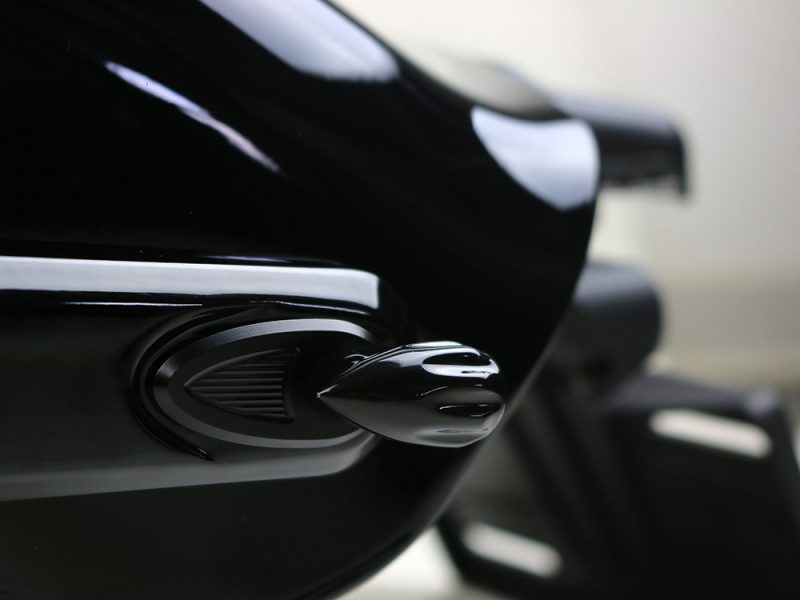 Shiny black motorcycle part with chrome accents.