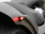 Bright LED motorcycle tail light on sleek matte motorcycle body, ideal for motorcycle safety and visibility.
