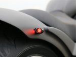 Red LED tail light on a motorcycle, close-up shot emphasizing safety features.