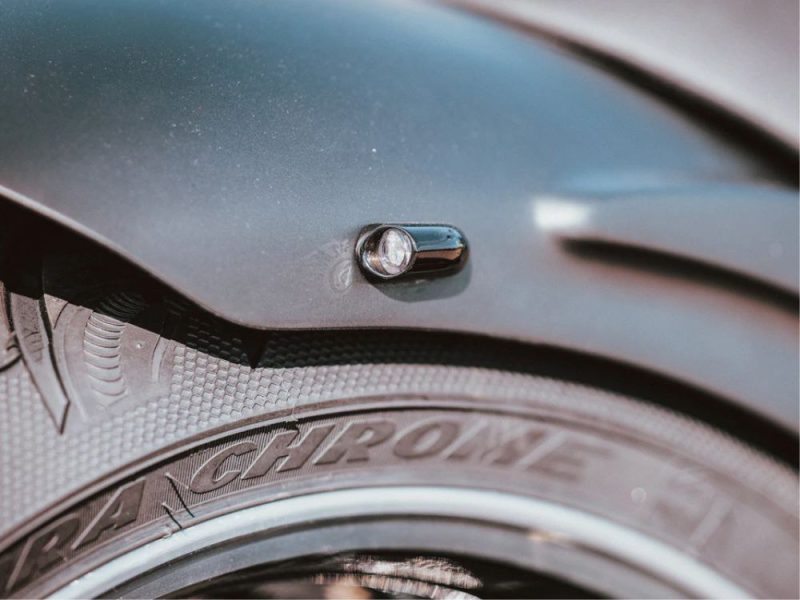 Close-up of a motorcycle tire and fender with the Revelry Motorcycles logo.