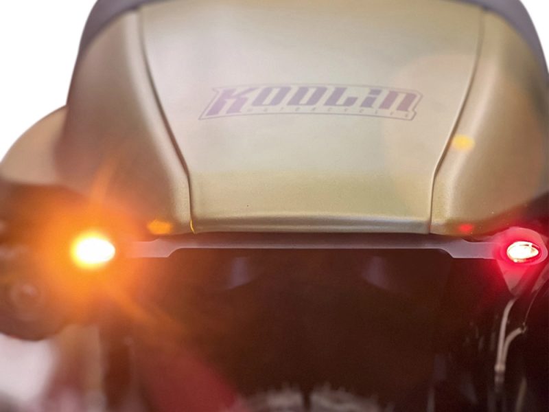 Suspected motorcycle rear view with illuminated taillights and "KOUCHAN" sticker, highlighting custom motorcycle accessories.