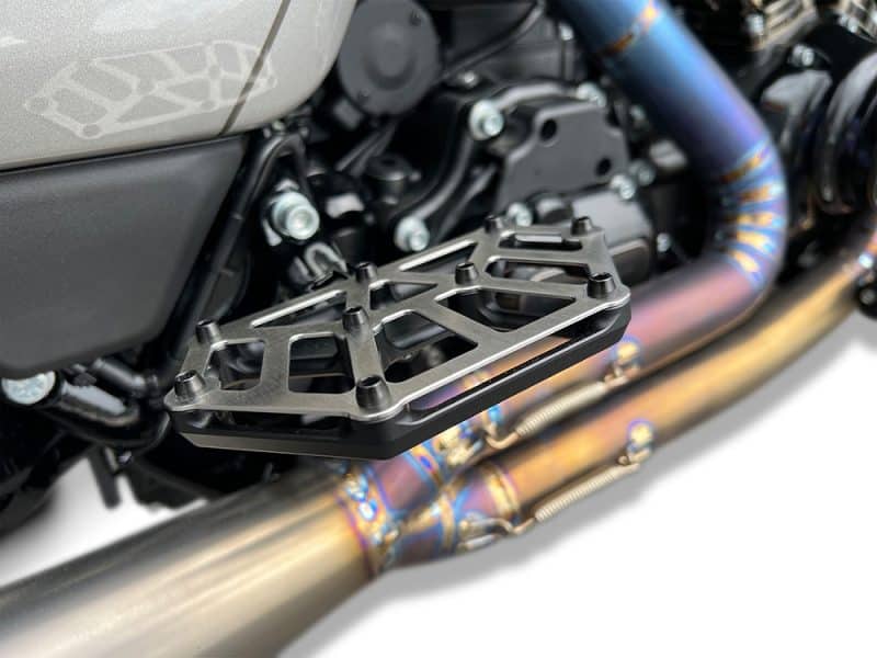 Lightweight motorcycle footpeg with black anodized finish on a high-performance bike.