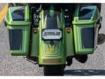 Vibrant green motorcycle with custom KoDin motoracing branding and storage compartments for touring.