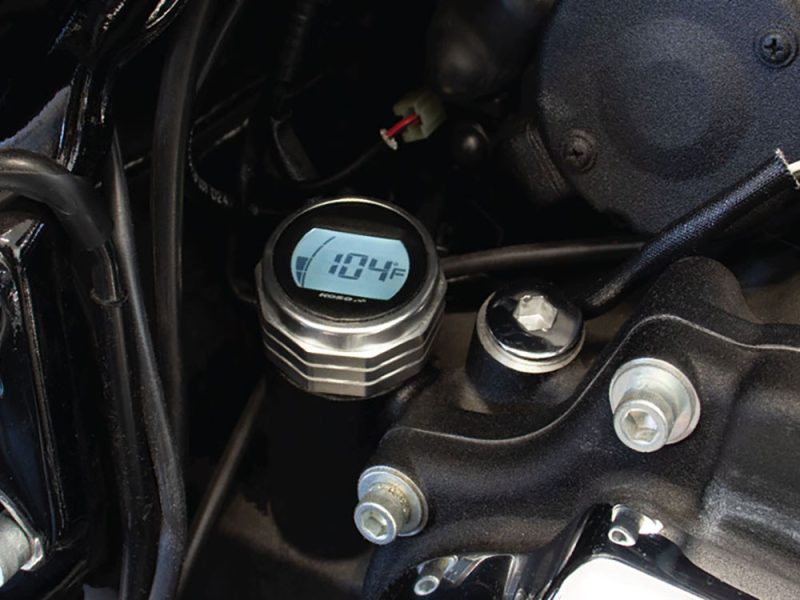 Digital motorcycle temperature gauge displaying 104°F.