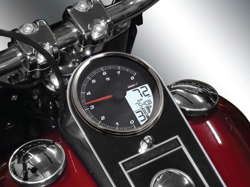 Motorcycle speedometer and digital display on a classic Revelry Cycles motorcycle, showcasing precision gauges and vintage-inspired design.
