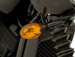 Motorcycle front turn signal and radiator grille close-up photo.