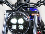 Vivid LED motorcycle headlight with black casing and chrome forks, perfect for custom Revelry motorcycles.