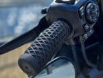 Rubber motorcycle handlebar grip with geometric pattern, close-up view.