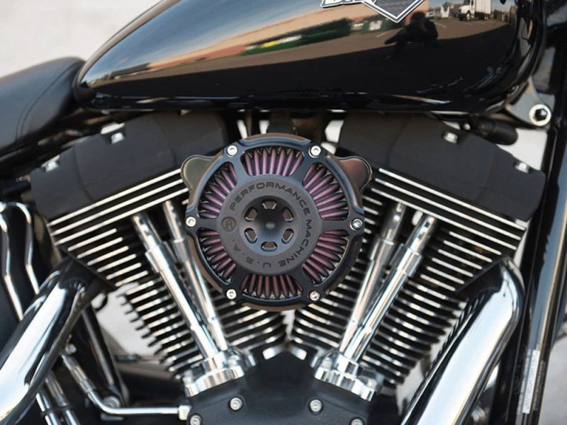 V-twin motorcycle engine with chrome details, ATV air filter, black and chrome finish, close-up shot.