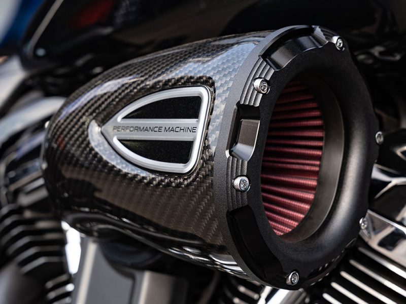 Carbon fibre motorcycle performance air intake with red filter element, enhanced engine airflow, and high-performance components.