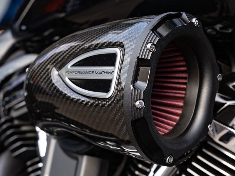 High-performance motorcycle air filter with carbon fibre casing and red air intake, ideal for enhancing bike power and efficiency.