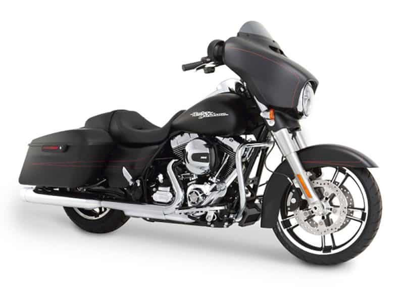 Harley-Davidson touring motorcycle with custom black and red accents, panniers, and a large front fairing.