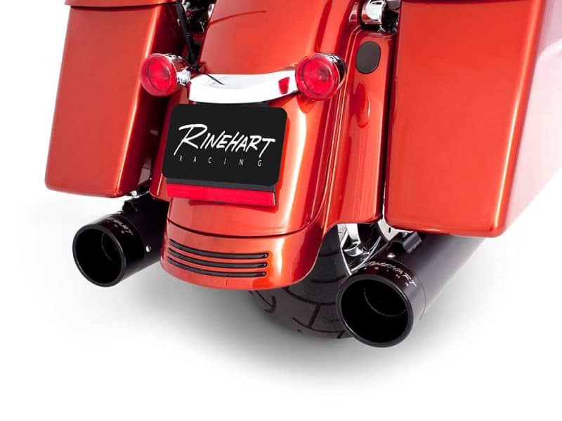 Vivid red motorcycle exhaust pipes with "Revelry Motorcycles" branding, showcasing custom racing exhausts.