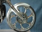 Chrome motorcycle wheel and disc brake close-up, high-performance bike parts.
